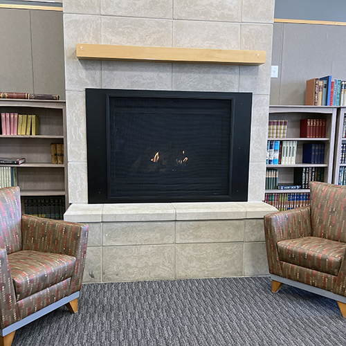 Fireplace with comfortable chairs and bookcases