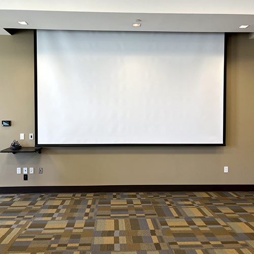 White projection screen hanging down from ceiling