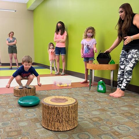 A boy plays leapfrog while others watch