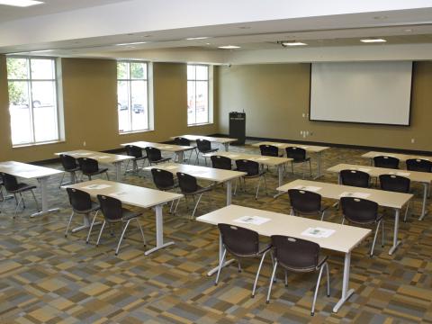 Large room with tables and a projector screen