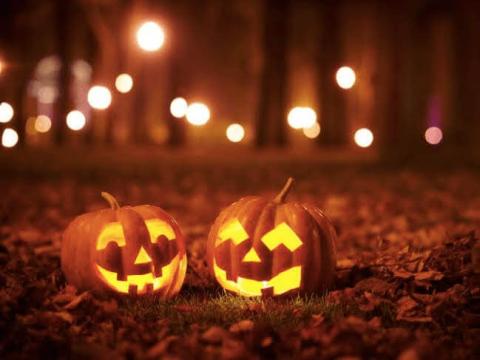 Two jack-o'-lanterns sitting on the ground.