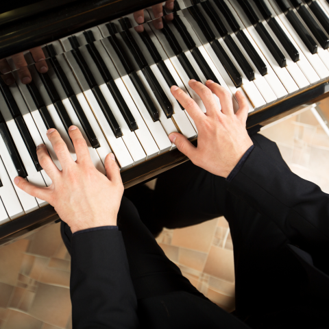 Close-up of hands playing piano keys