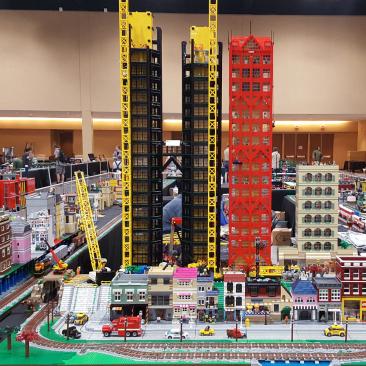 Room full of LEGO structures built into a city with skyscrapers