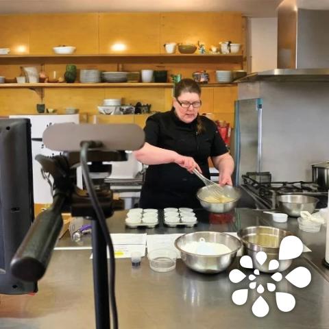 Chef holding a bowl and whisk.