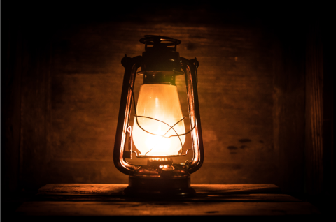 Old lantern glowing in a dark cave
