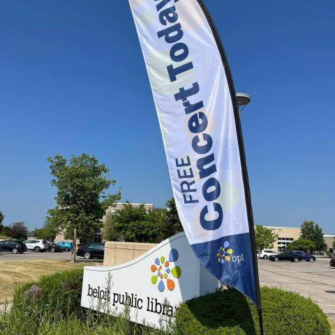 Free concert today feather flag in front of a monument sign