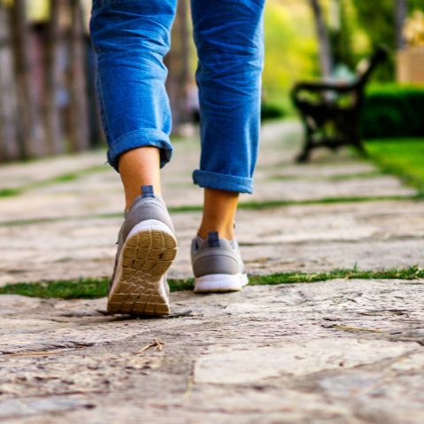 Close-up of woman's feet walking on a stone path