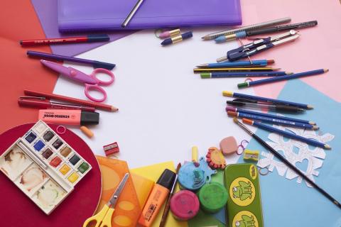 Art supplies laid out on a table with colorful papers