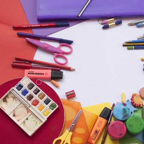 Art supplies laid out on a table with colorful papers