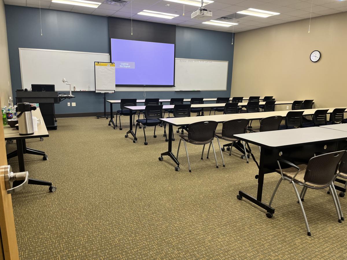 Classroom set up classroom style with projector screen in the front