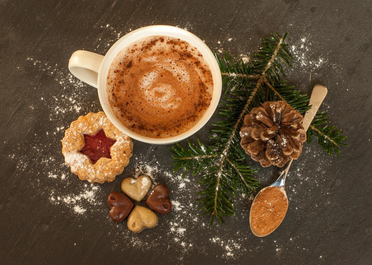 Image of hot chocolate, cookies, a pine cone, and a spoon.