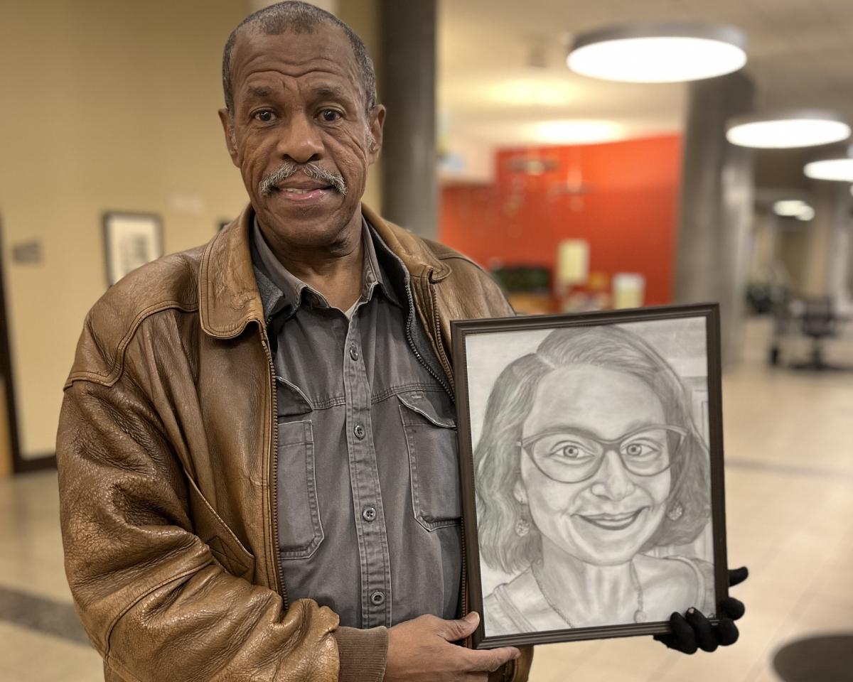 Artist John Martin holding a picture he drew