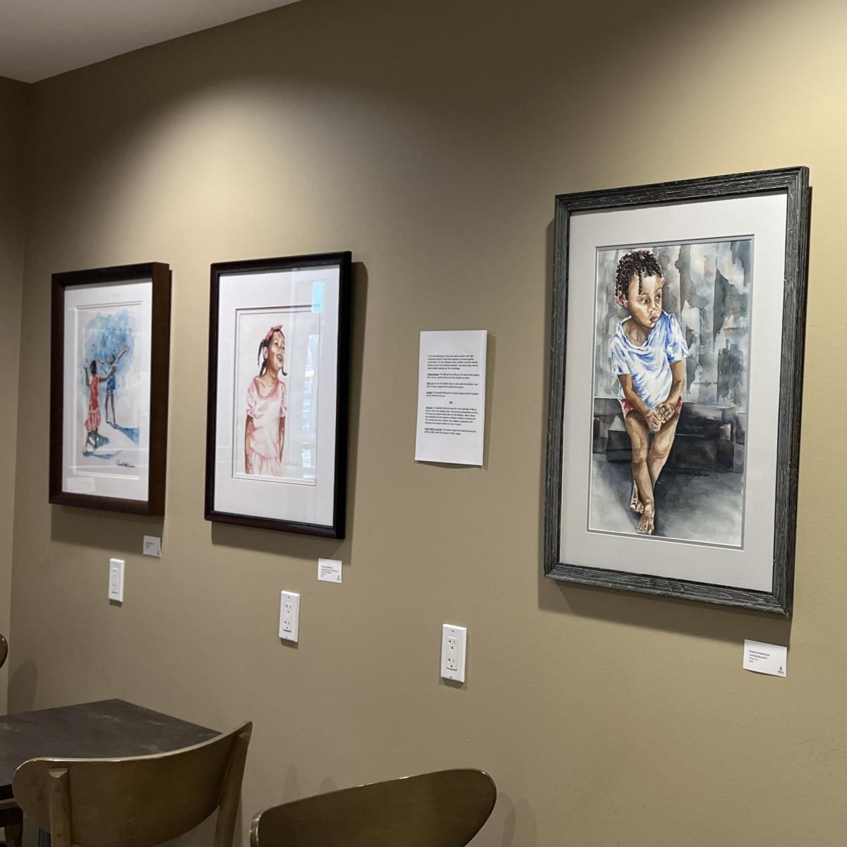 Three framed watercolor images featuring young children