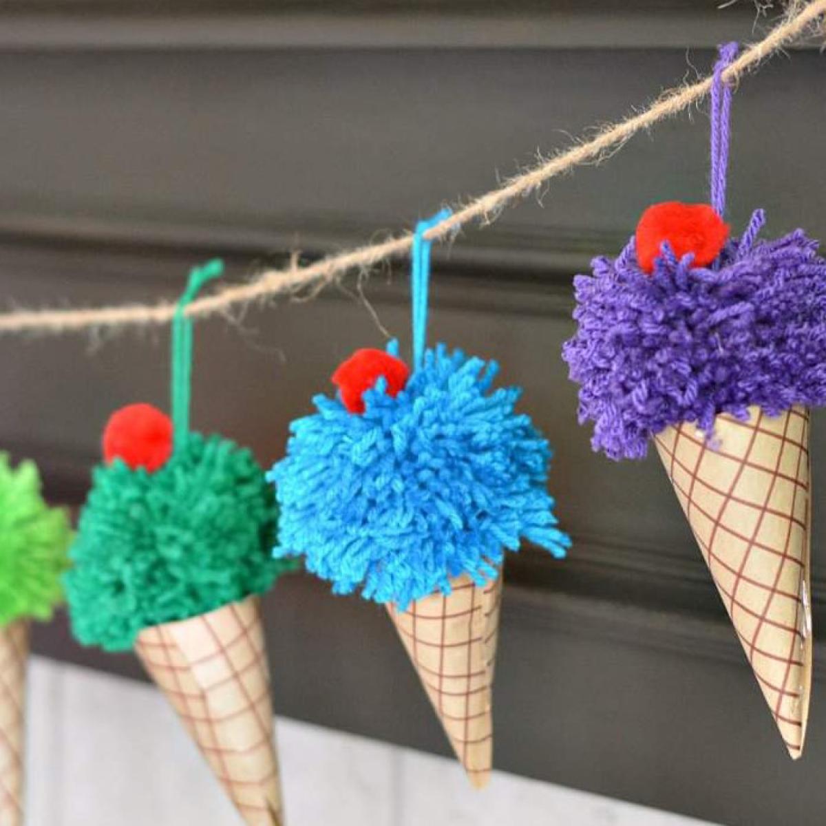 Colorful ice cream cone crafts hanging on twine on a fireplace mantle