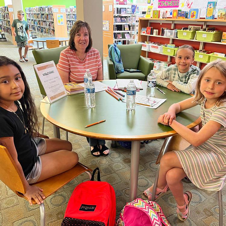 An adult and three children sitting around a table