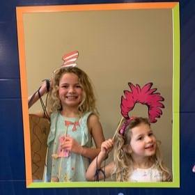 Two girls posing with Dr Seuss-themed photo props