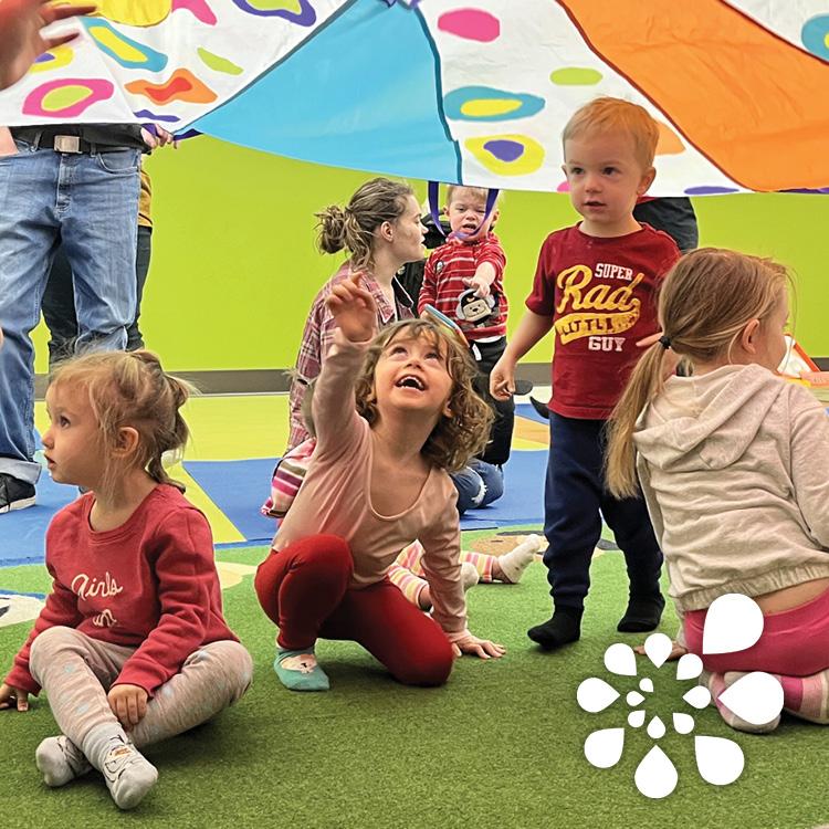 Children playing under a colorful parachute