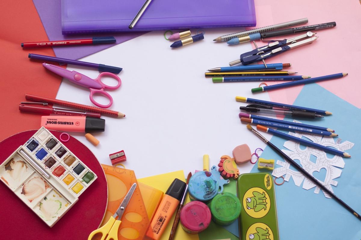 Art supplies laid out on a table with colorful papers
